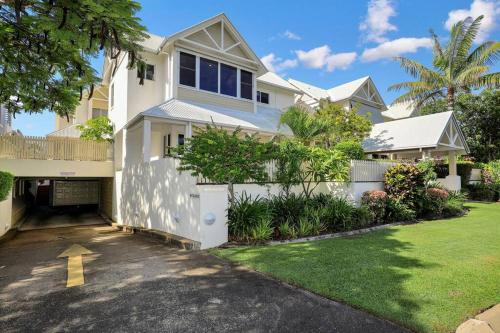 a white house with a driveway in front of it at Sandy Cove @ Royle Palms in Bargara