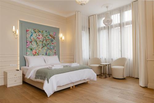1 dormitorio con 1 cama grande y una pintura en la pared en 1910 Boutique Hotel en Brasov