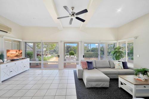 a living room with a couch and a ceiling fan at Sandy Cove @ Royle Palms in Bargara