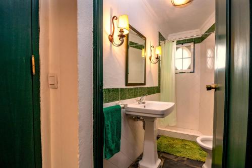 a bathroom with a sink and a toilet and a mirror at Casa Do Ginjal by NaturAlegre in Marvão