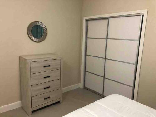 a bedroom with a bed and a dresser and a mirror at Jamaica Reggae Villa in Lucea