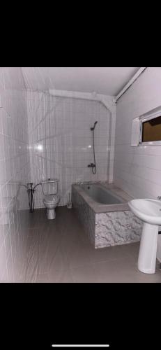 a bathroom with a tub and a toilet and a sink at Joli appartement ngor / Almadies in Ngor