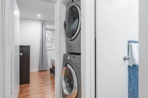 a washer and dryer with a tv on top of it at Littlewood Properties in Toronto