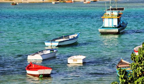 a group of boats sitting in the water at Passagem Concept Hotel e Spa in Cabo Frio