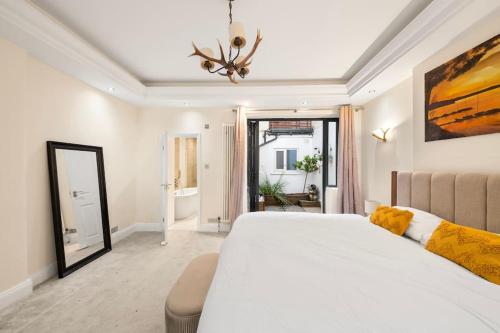 a bedroom with a large white bed and a mirror at Knightsbridge Residence with Garden Terrace in London