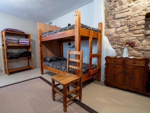 a bedroom with two bunk beds and a chair at Albergue de peregrinos en CIRAUQUI - CASA MARALOTX Camino de Santiago in Cirauqui