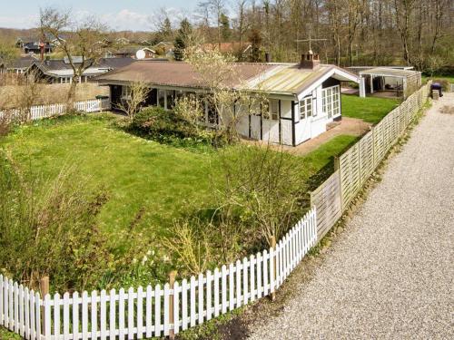 a white picket fence in front of a house at 6 person holiday home in Haderslev in Haderslev