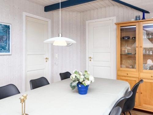 a dining room table with a vase of flowers on it at 9 person holiday home in Børkop-By Traum in Børkop