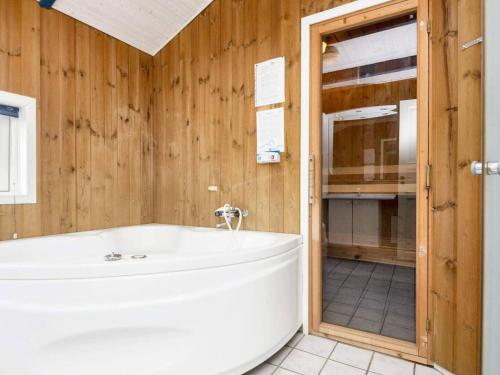 ボルコップにあるTwo-Bedroom Holiday home in Kalundborg 2の木製の壁のバスルーム(バスタブ付)