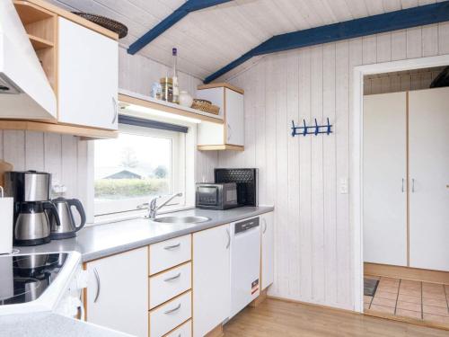 a kitchen with white cabinets and a window at 9 person holiday home in Børkop-By Traum in Børkop