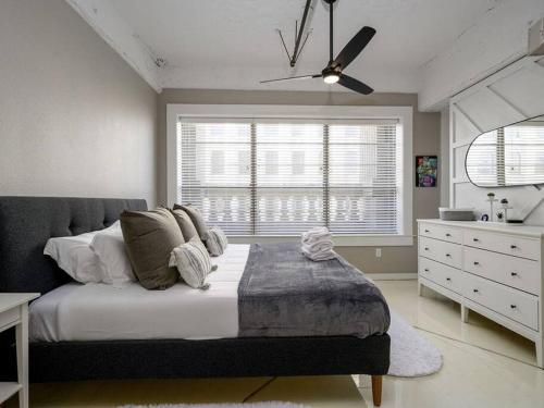 a bedroom with a bed and a dresser and a window at Downtown Memphis Luxury Condo in Memphis