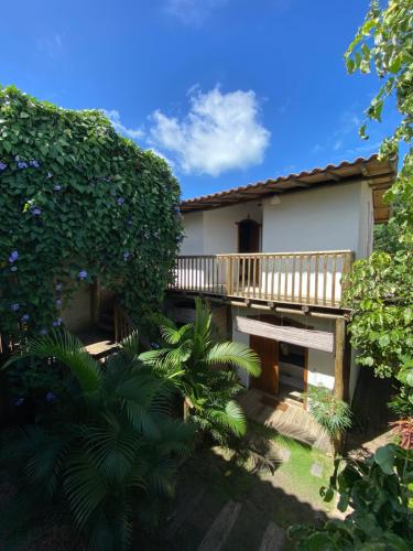 a house with a wooden deck and some plants at Pousada Dendê Caraiva in Caraíva
