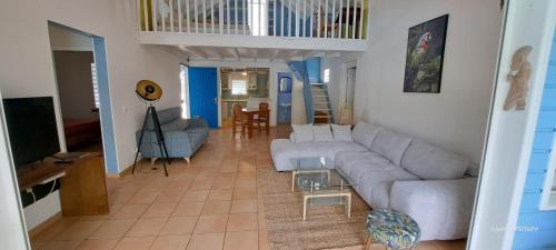 una sala de estar con un sofá y una mesa en Villa Standing Accès Privé Plage, en Sainte-Rose