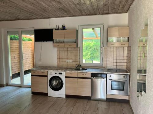Il comprend une cuisine équipée d'un lave-linge et d'un sèche-linge. dans l'établissement Liget, à Balatonföldvár