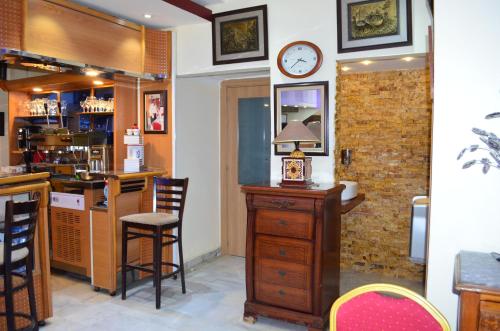 a kitchen with a counter and a clock on a wall at Hôtel le convivial in Jijel