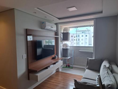 a living room with a tv and a couch at Casa 6 Encanto dos Mares in Itajaí
