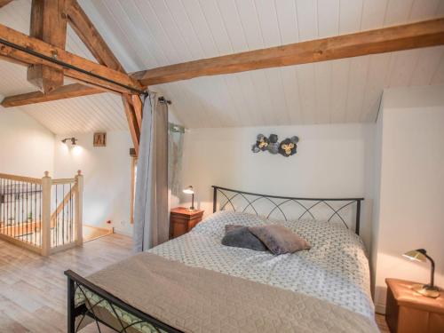 1 dormitorio con 1 cama en una habitación con techos de madera en Le Tourel, en Saint-Cernin-de-lʼHerm