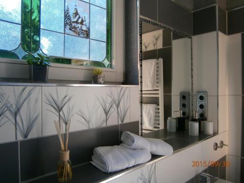 a bathroom with a mirror and towels on a counter at Paul Lincke Residenz in Hahnenklee-Bockswiese