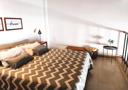 a bedroom with a large bed and a balcony at PRANA LoFT URBANO in Mendoza