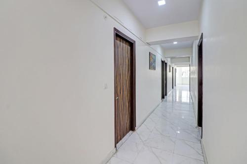 einen Flur mit weißen Wänden, einer Tür und Fliesenboden in der Unterkunft OYO Town Plaza in Neu-Delhi