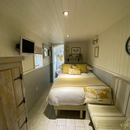 a bedroom with two beds and a tv on the wall at Woodmans Huts in Haverthwaite