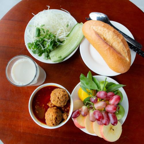 un tavolo di legno con piatti di cibo sopra di Carnival Villa a Da Lat