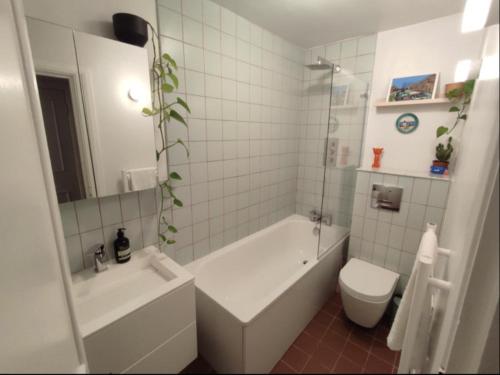 a bathroom with a tub and a toilet and a sink at Chapelstone in London