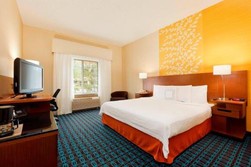 a hotel room with a bed and a flat screen tv at Fairfield Inn & Suites Portland South/Lake Oswego in Lake Oswego