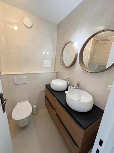 La salle de bains est pourvue d'un lavabo, de toilettes et de miroirs. dans l'établissement Chic 2 Rooms Paris13 with view, à Paris