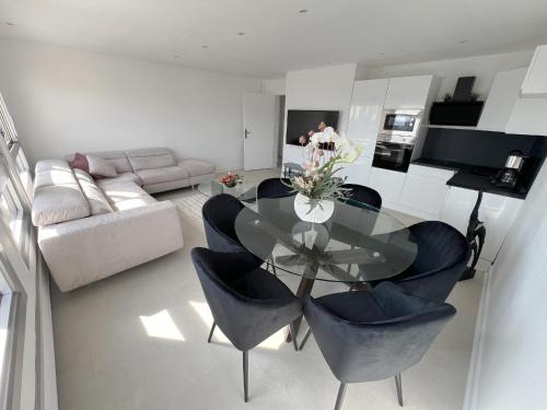 un salon avec une table en verre et des chaises dans l'établissement Chic 2 Rooms Paris13 with view, à Paris