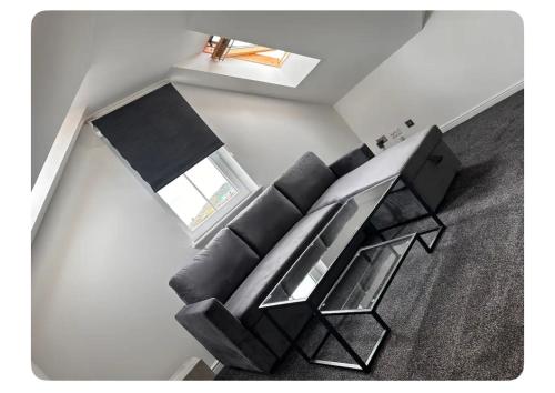 a living room with a black couch and a glass table at Giles Apart in Edinburgh