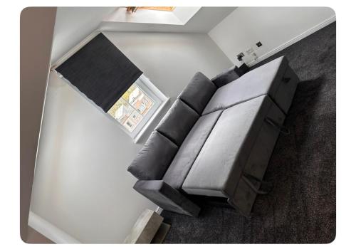 a living room with a leather couch and a window at Giles Apart in Edinburgh