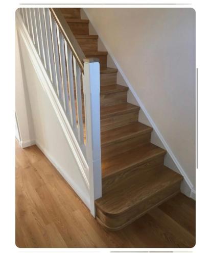 una escalera con suelo de madera y paredes blancas en Giles Apart, en Edimburgo
