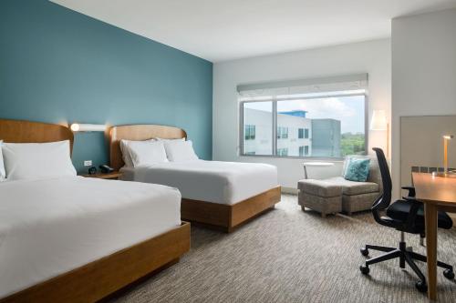 a hotel room with two beds and a desk at Element Orlando International Drive in Orlando