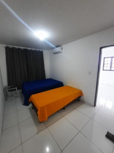 a room with a bed with a blue and orange blanket at Casa Buzios do Francês in Marechal Deodoro