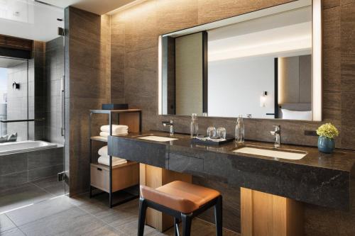 a bathroom with two sinks and a large mirror at TIAD, Autograph Collection in Nagoya