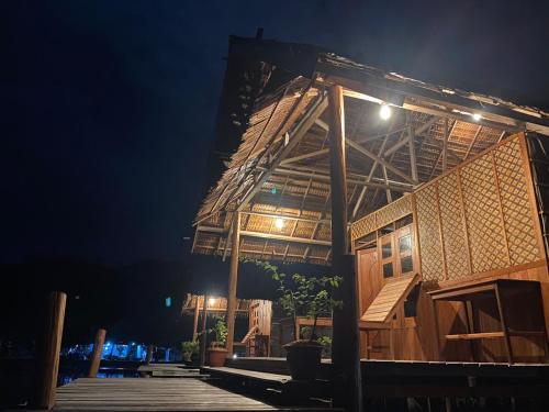 a building with a lit up roof at night at Indos Homestay-Raja Ampat in Besir