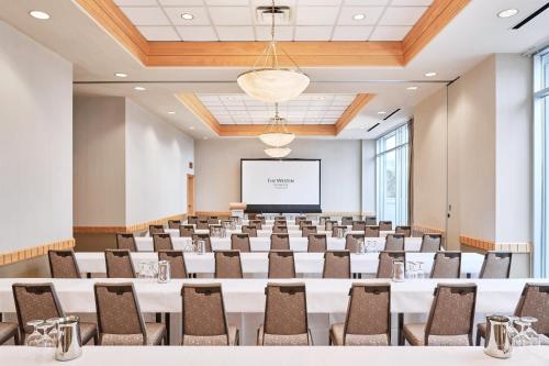 a conference room with tables and chairs and a projection screen at The Westin Bayshore, Vancouver in Vancouver