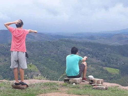 two young men sitting on top of a mountain at Casa Centenária localizada no calçadão de SLP in São Luiz do Paraitinga