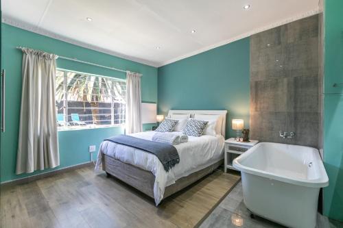a bedroom with a bed and a tub and a window at Kelvin Maison's Haven in Johannesburg