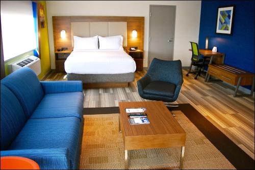 a hotel room with a bed and a blue couch at Holiday Inn Express Vancouver Airport-Richmond, an IHG Hotel in Richmond