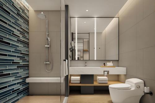 a bathroom with a sink and a toilet and a mirror at Fairfield by Marriott Hangzhou Wulin Square, China in Hangzhou