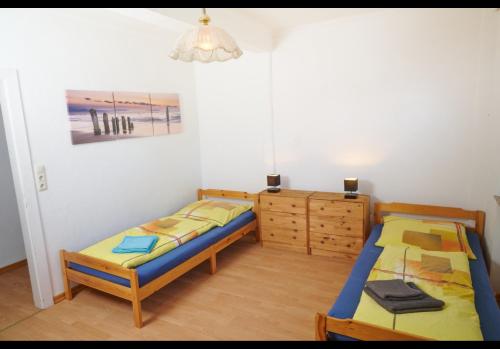 マイナーツハーゲンにあるSchöne Unterkunft mit Billardのベッドルーム1室(ツインベッド2台、ドレッサー付)