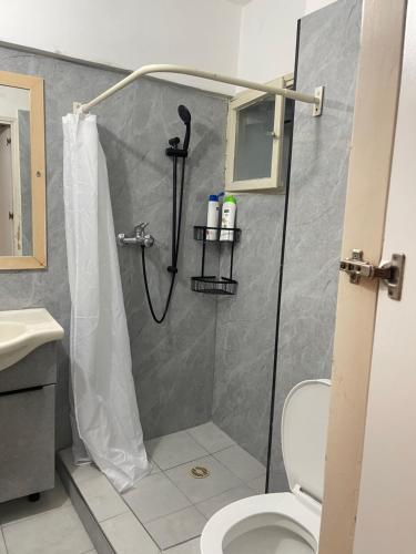 a bathroom with a shower with a toilet at שבטי ישראל - דירת בוטיק in Haifa