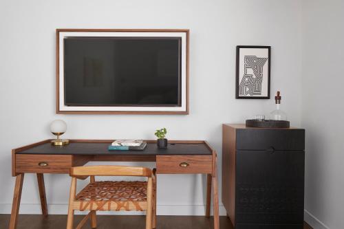 a desk with a chair and a television on a wall at Kimpton Virgilio in Mexico City