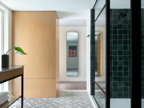 ein Bad mit einer Dusche und einem Spiegel in der Unterkunft Kimpton Virgilio in Mexiko-Stadt
