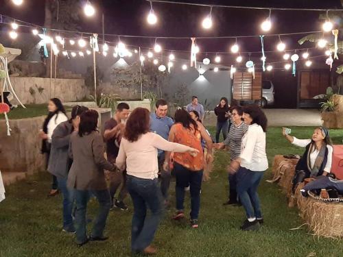 a group of people dancing in the grass at night at Villa Elizabeth - Tú Hermosa Casa de Campo in Lima