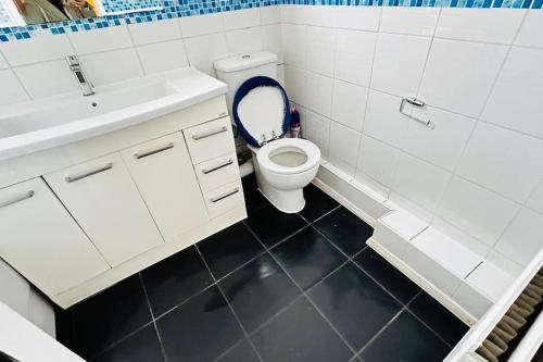 ein weißes Bad mit einem WC und einem Waschbecken in der Unterkunft 3 Bed House East London Home in London