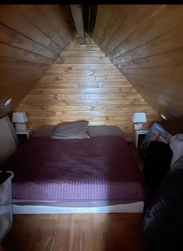 - une chambre avec un lit violet dans un grenier en bois dans l'établissement Petit paradis accueillant piscine proche CNFDI Chambre privée, à Brunoy