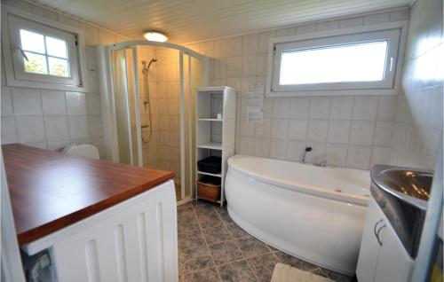 a small bathroom with a tub and a sink at Beautiful Home In Vinderup With Kitchen in Vinderup